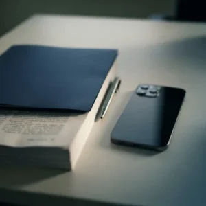 Telemóvel e bloco de notas sobre uma secretária